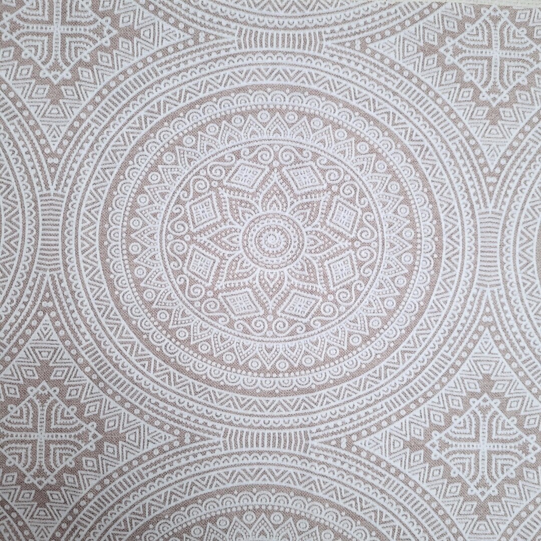 Beigefarbener Stoff mit weißem Mandala-Muster im Detail